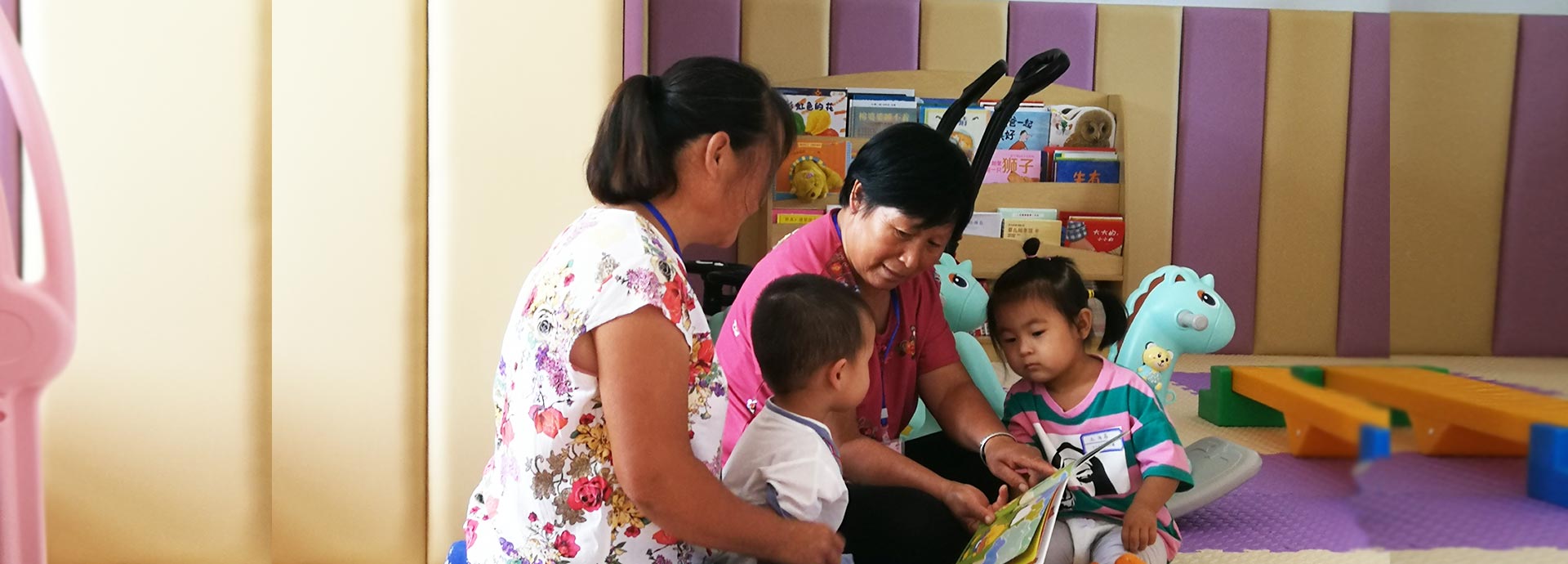 家长在儿童早期发展中心给孩子讲读绘本