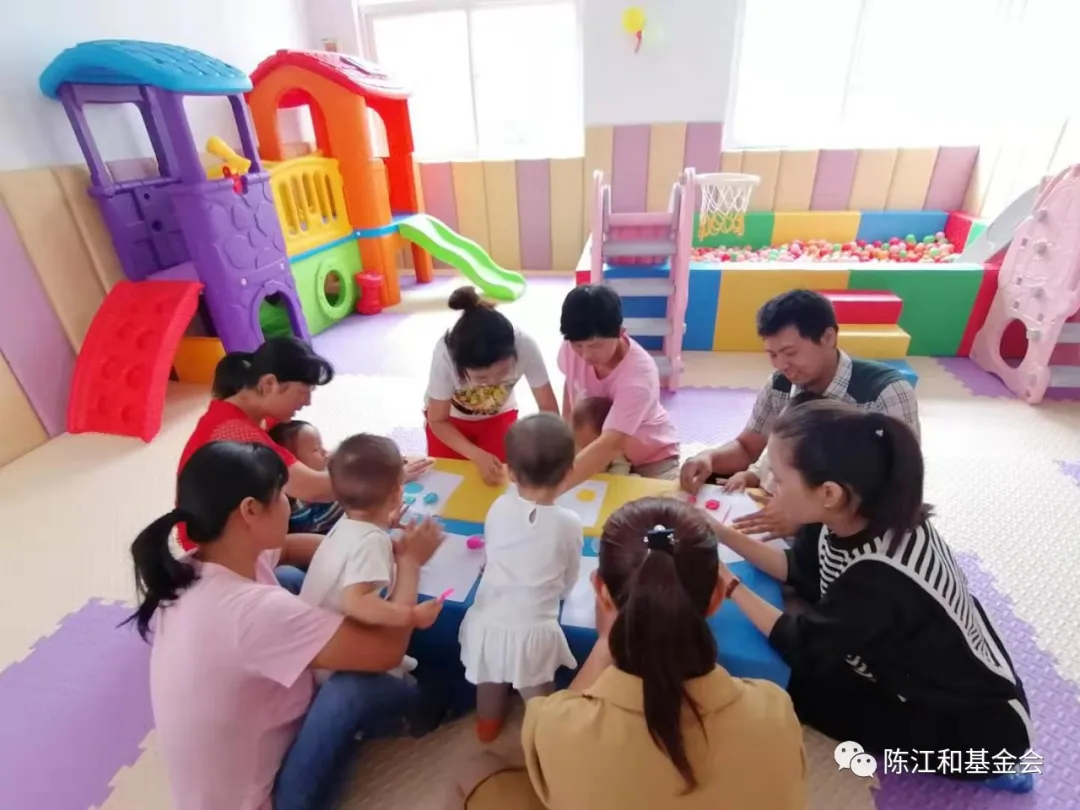 养育师带领婴幼儿及家长进行集体手工活动